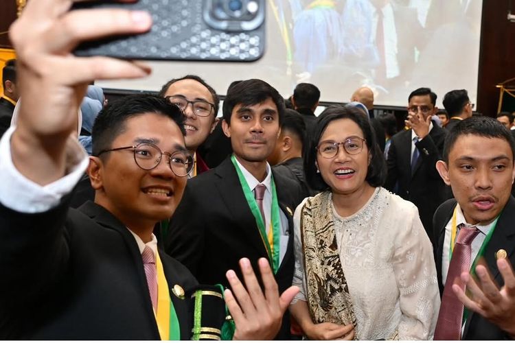 Sri Mulyani, sri mulyani fashion, sri mulyani hadir di wisuda anak, anak sri mulyani, adwin haryo indrawan, 7 Style Sri Mulyani saat Hadiri Wisuda Anak, Kenakan Tunik dan Batik, 1. Tunik putih tulang, 2. Aksen brokat dan renda yang halus, 3. Kain batik bernuansa cokelat, 4. Selendang batik, 5. Heels nude pumps, 6. Rambut bob signature, 7. Aksesori minimalis