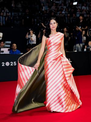 Dian Sastrowardoyo, Dian Sastro, Busan International Film Festival, busana dian sastro, style dian sastro, 8 Detail Outfit Dian Sastro di Busan International Film Festival 2025, Kenakan Gaun Stripes, 1. Gaun stripes rancangan Sebastian Gunawan, 2. Detail draperi yang dramatis, 3. Aksen kain hijau olive, 4. Gaya rambut loose waves, 5. Riasan natural yang menonjolkan mata, 6. Kompak dengan Ali Fikry, 7. Reuni dengan Nicholas Saputra, 8. Aksesori minimalis
