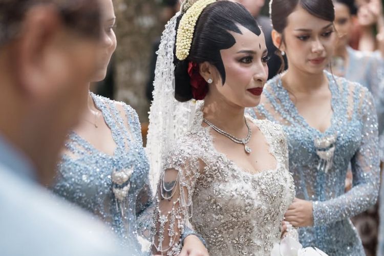 Jennifer Coppen, Justin Hubner, 5 Gaya Akad Nikah Jennifer Coppen dan Justin Hubner, Balutan Adat Jawa, 1. Jennifer tampil anggun dengan kebaya putih berhiaskan payet, 2. Riasan paes memperkuat nuansa adat Jawa, 3. Sanggul klasik dihiasi aksen bunga merah, 4. Justin Hubner tampil gagah dengan beskap putih, 5. Blangkon dan ronce melati melengkapi penampilan