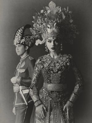 7 Detail Busana Adat Gorontalo Syifa Hadju dan El Rumi saat Prewedding, Serba Merah, 1. Dominasi warna merah yang menjadi pusat perhatian, 2. Mahkota tinggi dengan ornamen emas pada busana Syifa, 3. Detail payet penuh di bagian dada dan bahu, 4. Lengan transparan dengan payet merah, 5. Sabuk emas lebar sebagai penegas siluet, 6. Busana El Rumi bergaya formal dengan aksen emas, 7. Perpaduan keseluruhan tampak serasi dan berkarakter