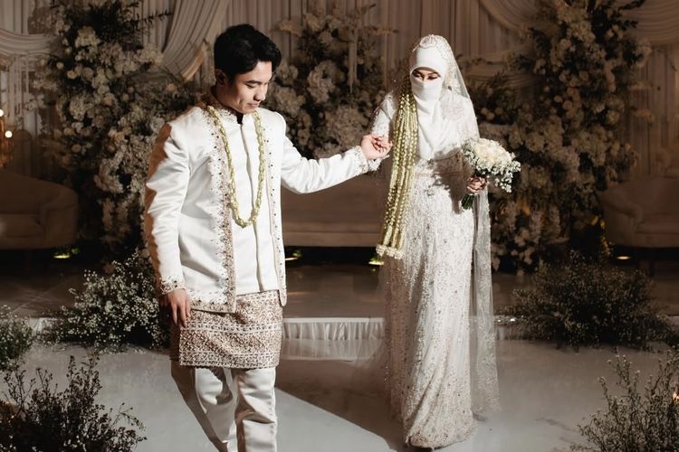 Tinandrose, akad nikah, menikah, Fiki Naki, fiki naki menikah, Fiki Naki menikahi Tinandrose, Fiki Naki menikah dengan Tinandrose, Tinandrose fiki naki, Tinandrose Buku, Fiki Naki dan Tinandrose Menikah, Elegan dalam Busana Serba Putih, Momen lamaran Fiki Naki dan Tinandrose, Busana Fiki Naki saat akad nikah, dihiasi payet, Tinandrose saat akad nikah, pakai veil transparan, Busana resepsi Fiki Naki dan Tinandrose dalam nuansa beige