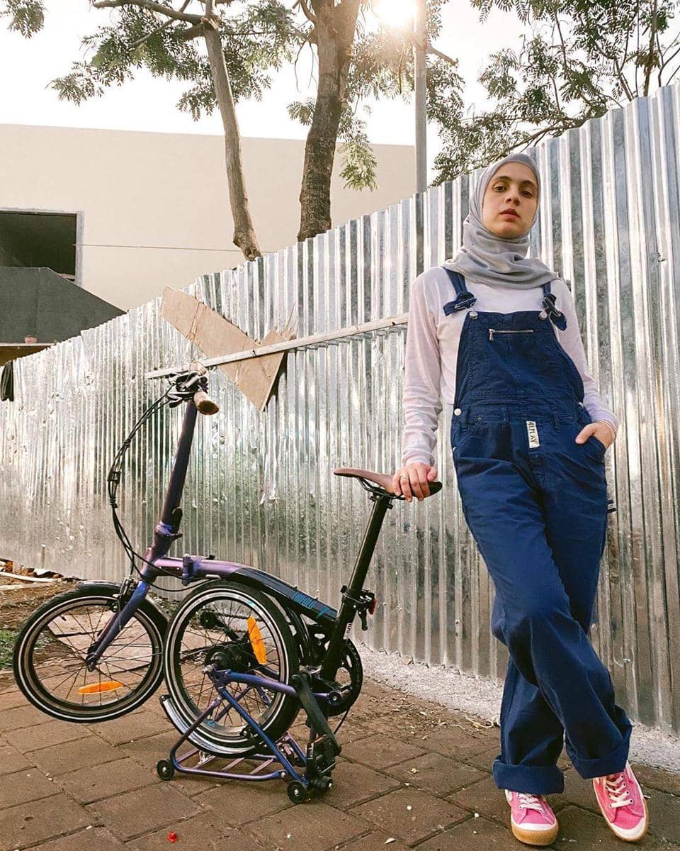 1. Ayudia C. punya karakter gaya yang kasual. Hijab berwarna hitam memberikan nuansa yang netral. Cocok dikenakan bersama kemeja berwarna orange, boyfriend jeans, sneakers andalan, dan juga tas kecil untuk membawa barang., 2. Alyssa Soebandono tampil kekinian dengan warna senada serba lilac, mulai dari hijab hingga celana. Dilapisi outer berwarna hijau army, dilengkapi dengan sneakers dan juga topi, bikin gaya kamu jadi semakin asik!, 3. Nycta Gina mengenakan ootd dengan sentuhan warna soft dari hijab abu, atasan warna putih, disempurnakan dengan overall berwarna navy yang standout banget. Jangan lupa berikan aksen yang menawan dengan memakai sneakers berwarna vibrant untuk menjadi fashion statement ya, AlongWalker., 4. Zaskia Mecca tampak simple tapi fun! Mengenakan hijab hitam sebagai essentials, kemudian memakai atasan lengan panjang warna kontras yang di-layer dengan graphic t-shirt lengan pendek, dipasangkan dengan celana katun berwarna hitam. Untuk photo-shoot yang quirky, kamu bisa juga memakai helm unik dan jenaka seperti yang sedang dikenakan Zaskia ini, lho., 5. Sivia Azizah dikenal dengan ootd boyish look. Biasa mengenakan hijab hitam yang netral, ketemu oversized blazer yang on trend banget. Nggak lupa disempurnakan dengan mengenakan celana hitam yang basic untuk bikin tampilan semakin chic.