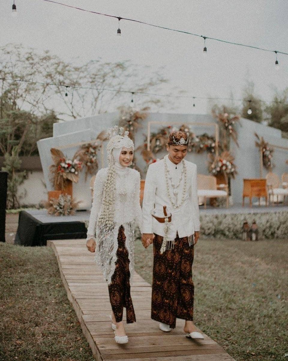 instagram.com/helminursifah, 1. Tampil manis dengan kebaya khas Sunda yang sederhana. Lengkap dengan siger atau mahkota pernikahan khas adat Sunda., 2. Dress putih model brokat yang simpel bisa jadi pilihan untuk kamu yang anti ribet. Supaya lebih spesial, tambahkan aksesori di atas kepala dengan veil yang anggun., 3. Jangan ragu coba pakai kebaya model off-shoulder di hari pernikahan. Detail pearl pada kebaya dijamin membuat penampilan jadi lebih maksimal., 4. Bergaya a la putri keraton Yogyakarta dengan kebaya adat Jawa yang anggun. Andalkan kebaya klasik model kutubaru dengan aksen bordir yang menutupi bagian pundak., 5. Lace dress dengan dasar warna putih memang tidak pernah gagal untuk baju akad nikah yang elegan. Makin sempurna dengan hiasan kepala berupa tudung pernikahan yang seragam dengan bahan gaun.