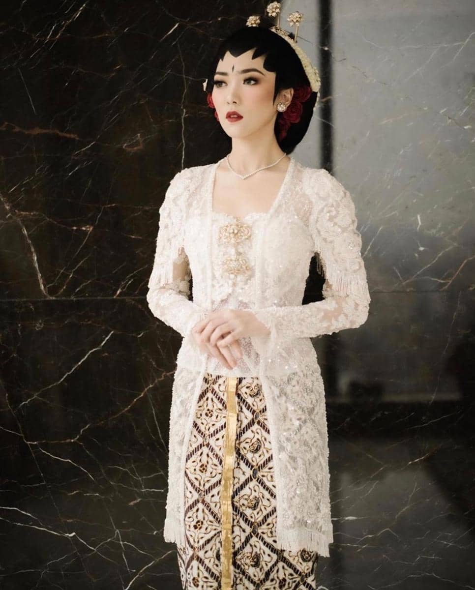 alexandra.bridestory.com, 1. Tampil manis dengan kebaya khas Sunda yang sederhana. Lengkap dengan siger atau mahkota pernikahan khas adat Sunda., 2. Dress putih model brokat yang simpel bisa jadi pilihan untuk kamu yang anti ribet. Supaya lebih spesial, tambahkan aksesori di atas kepala dengan veil yang anggun., 3. Jangan ragu coba pakai kebaya model off-shoulder di hari pernikahan. Detail pearl pada kebaya dijamin membuat penampilan jadi lebih maksimal., 4. Bergaya a la putri keraton Yogyakarta dengan kebaya adat Jawa yang anggun. Andalkan kebaya klasik model kutubaru dengan aksen bordir yang menutupi bagian pundak., 5. Lace dress dengan dasar warna putih memang tidak pernah gagal untuk baju akad nikah yang elegan. Makin sempurna dengan hiasan kepala berupa tudung pernikahan yang seragam dengan bahan gaun.