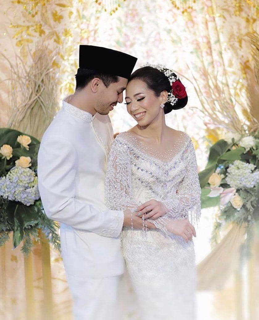 instagram.com/thebridebestfriend, 1. Tampil manis dengan kebaya khas Sunda yang sederhana. Lengkap dengan siger atau mahkota pernikahan khas adat Sunda., 2. Dress putih model brokat yang simpel bisa jadi pilihan untuk kamu yang anti ribet. Supaya lebih spesial, tambahkan aksesori di atas kepala dengan veil yang anggun., 3. Jangan ragu coba pakai kebaya model off-shoulder di hari pernikahan. Detail pearl pada kebaya dijamin membuat penampilan jadi lebih maksimal., 4. Bergaya a la putri keraton Yogyakarta dengan kebaya adat Jawa yang anggun. Andalkan kebaya klasik model kutubaru dengan aksen bordir yang menutupi bagian pundak., 5. Lace dress dengan dasar warna putih memang tidak pernah gagal untuk baju akad nikah yang elegan. Makin sempurna dengan hiasan kepala berupa tudung pernikahan yang seragam dengan bahan gaun.