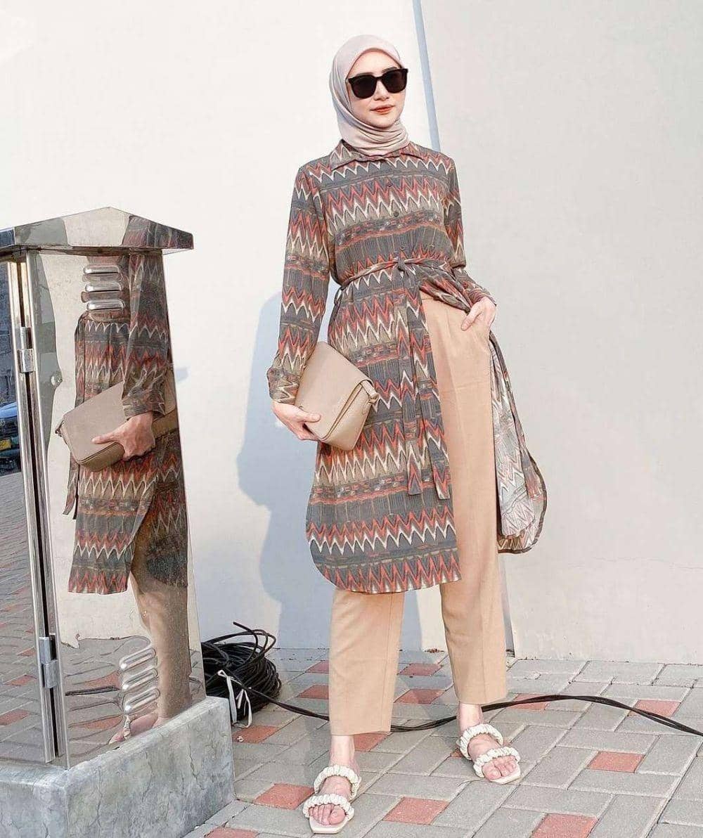 instagram.com/bahjatina, 1. Gaya kasual dijamin lebih modis pakai baju tunik berbahan denim. Pasangkan dengan kulot dan mesh bag yang kekinian., 2. OOTD hangout yang elegan, coba kenakan baju tunik model turtleneck. Supaya lebih maksimal, lengkapi dengan celana putih dan ankle-strap heels berwarna senada., 3. Outfit hijab yang lebih seru pakai slit tunic bermotif. Padu-padankan dengan bawahan netral dan sandals yang nyaman., 4. Saatnya upgrade gayamu pakai asymmetrical tunic yang fashionable. Cukup pasangkan dengan celana jeans dan sling bag andalan., 5. Tampil anggun dengan baju tunik model tulle yang manis. Pilih celana putih dan transparent heels sebagai pelengkap, cocok dipakai untuk hadiri pesta pernikahan.
