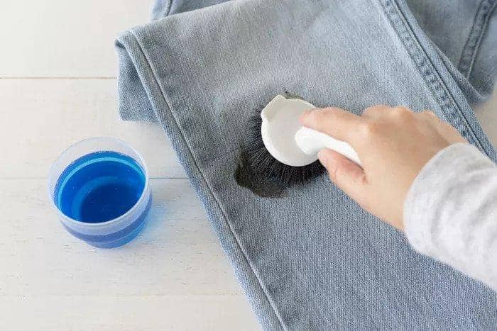 1. Cara pertama yang bisa kamu coba ialah dengan menggunakan detergen cair. Sebelum dicuci, oleskan detergen pada noda dan diamkan selama beberapa menit. Kemudian sikat secara perlahan hingga noda mulai memudar dan lanjutkan mencuci seperti biasa., 2. Baking soda memang ampuh bersihkan noda apa pun, termasuk oli. Taburkan baking soda pada noda dan sikat perlahan menggunakan sikat gigi bekas. Terakhir, cuci pakaian dengan air panas hingga bersih., 3. Selain baking soda, tepung maizena juga bisa jadi andalan. Siapkan alat lainnya seperti sikat gigi, lap, dan spons basah. Biarkan tepung maizena mengeras di atas noda selama 15 menit, gosok dengan alat yang sudah disiapkan hingga noda oli menghilang., 4. Manfaatkan sabun cuci piring yang ada di dapur. Cukup oleskan pada noda oli dan diamkan selama beberapa menit. Kemudian sikat dan cuci pakaian sesuai dengan label petunjuk pemakaian., 5. Selain berguna untuk kecantikan dan kelembapan rambut, gel lidah buaya juga ampuh hilangkan noda oli. Rendam pakaian dengan air panas, lalu oleskan gel lidah buaya pada bagian yang terkena noda. Lanjutkan dengan mencuci pakaian seperti biasa.