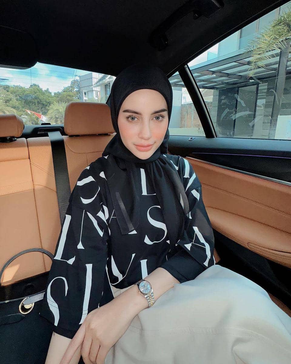 instagram.com/emyaghnia, 1. Gaya selfie kekinian di dalam mobil, coba arahkan wajah ke depan kamera dengan menundukkan sedikit kepalamu. Ini bisa jadi trik agar wajah nggak terlihat bulat saat memakai hijab., 2. Tampil playful dengan kolase foto selfie menggunakan timer. Ambil bangku dan berpose sambil duduk, lalu tunjukkan ekspresi terbaikmu., 3. Trik selfie yang lagi tren, gunakan kamera belakang dan atur pakai wide lens atau mode 0,5x. Cara ini bisa jadi andalan buat kamu yang nggak suka foto selfie yang terlalu nge-zoom., 4. Kalau ingin sekalian menampilkan OOTD modismu, foto mirror-selfie jawabannya. Arahkan kamera ke depan cermin untuk berpose dengan full-body., 5. Buat kamu yang masih kaku foto sendiri, selfie bersama teman atau keluarga terkasih juga nggak masalah. Foto selfie pun dijamin kelihatan lebih natural.