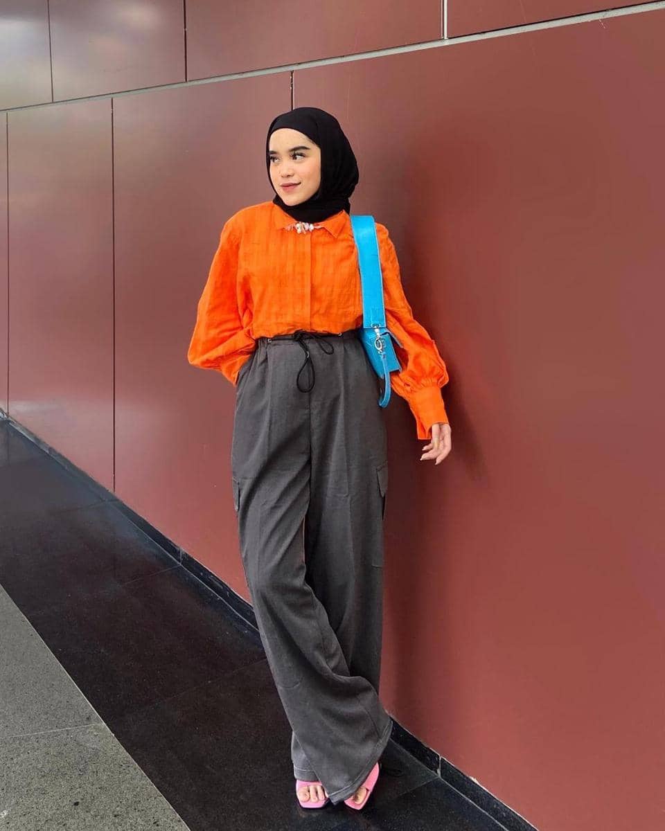 instagram.com/raihanand, 1. Coat bernuansa oranye cocok dipasangkan dengan outfit serba netral. Kombinasi crewneck dan hijab warna cokelat bisa jadi andalan., 2. Jangan ragu memadukan tie-waist dress oranye dengan warna mencolok lainnya. Pilih hijab dan shoulder bag serba warna electric blue yang kece., 3. Hijab putih memang cocok dipasangkan dengan warna apa pun, termasuk sweater oranye. Makin modis pakai white quilted vest sebagai pelengkap., 4. Selain putih, hijab hitam juga nggak pernah gagal untuk outfit apa pun. Kenakan kemeja oranye dan bawahan cargo pants, lengkap dengan square-toe heels yang kekinian., 5. Padu-padan blus dan wide pants serba oranye tampak senada dengan hijab krem yang simpel. Tambahkan pink belt untuk mempermanis penampilan.