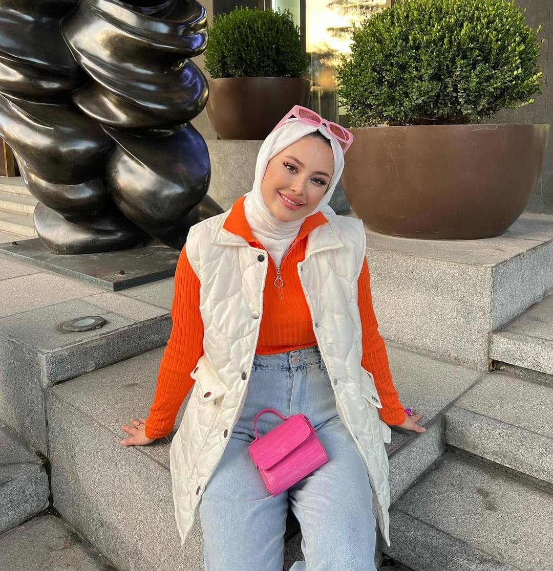 pinterest.com, 1. Coat bernuansa oranye cocok dipasangkan dengan outfit serba netral. Kombinasi crewneck dan hijab warna cokelat bisa jadi andalan., 2. Jangan ragu memadukan tie-waist dress oranye dengan warna mencolok lainnya. Pilih hijab dan shoulder bag serba warna electric blue yang kece., 3. Hijab putih memang cocok dipasangkan dengan warna apa pun, termasuk sweater oranye. Makin modis pakai white quilted vest sebagai pelengkap., 4. Selain putih, hijab hitam juga nggak pernah gagal untuk outfit apa pun. Kenakan kemeja oranye dan bawahan cargo pants, lengkap dengan square-toe heels yang kekinian., 5. Padu-padan blus dan wide pants serba oranye tampak senada dengan hijab krem yang simpel. Tambahkan pink belt untuk mempermanis penampilan.