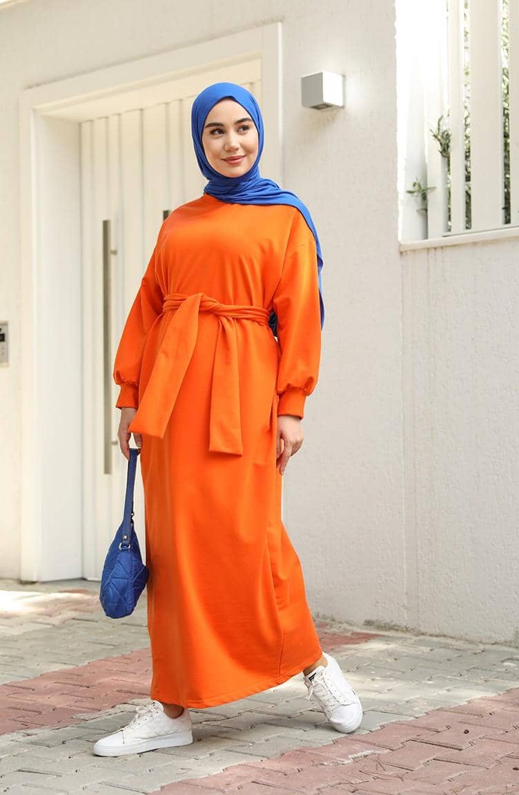 sefamerve.com, 1. Coat bernuansa oranye cocok dipasangkan dengan outfit serba netral. Kombinasi crewneck dan hijab warna cokelat bisa jadi andalan., 2. Jangan ragu memadukan tie-waist dress oranye dengan warna mencolok lainnya. Pilih hijab dan shoulder bag serba warna electric blue yang kece., 3. Hijab putih memang cocok dipasangkan dengan warna apa pun, termasuk sweater oranye. Makin modis pakai white quilted vest sebagai pelengkap., 4. Selain putih, hijab hitam juga nggak pernah gagal untuk outfit apa pun. Kenakan kemeja oranye dan bawahan cargo pants, lengkap dengan square-toe heels yang kekinian., 5. Padu-padan blus dan wide pants serba oranye tampak senada dengan hijab krem yang simpel. Tambahkan pink belt untuk mempermanis penampilan.