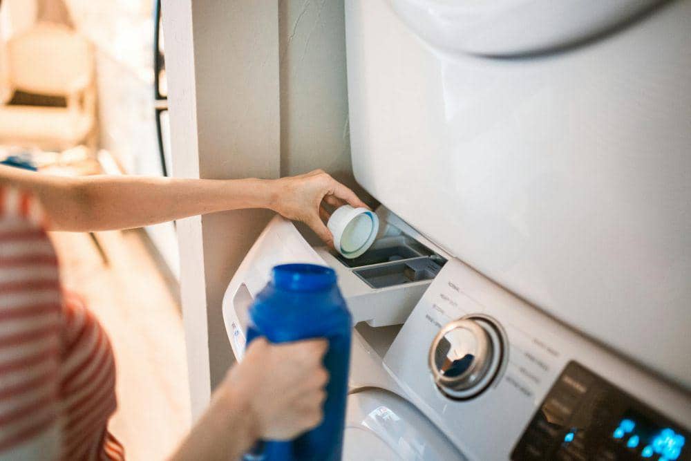 ilustrasi detergen kemasan botol besar saat mencuci pakaian (pexels.com/RDNE Stock project), 1. Kelebihan bahan yoris, 2. Kekurangan bahan yoris, 3. Material dasar bahan yoris, 4. Bahan yoris cocok untuk pakaian apa?, 5. Tips merawat bahan yoris agar awet