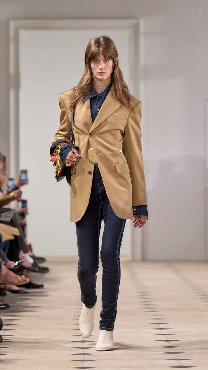 Look 01.jpg, 1. Gaya preppy yang tetap mewah, 2. Styling dengan permainan siluet yang kontras , 3. Scarf jadi item wajib di runway, 4. Genderless vibe , 5. Koleksi yang penuh makna dan cerita personal bagi Michael Rider