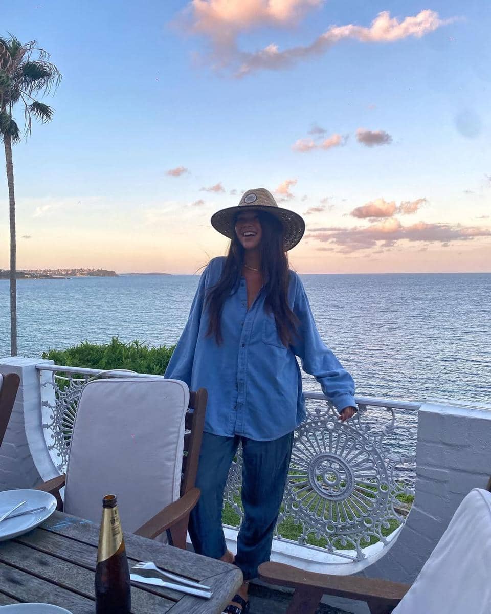 sunsets here feel like sprinkles of magic from oma&amp;opa watching over fairy bower 🧚.jpg, 1. Menikmati liburan di Sydney, Jaz Rowe tampil stylish pakai kemeja dan celana denim berpotongan longgar dengan topi anyam., 2. Bergaya streetwear, Jazmine memadupadankan kemeja motif garis warna pink dengan celana hitam potongan longgar serta sneakers motif leopard., 3. Jaz Rowe andalkan setelan bra top dan celana pendek crochet dengan motif senada. Kalung dan gelang bikin nuansa ala island girl makin terpancar., 4. Jazmine tampil dengan pesona pageant beauty dalam balutan dress ungu yang pas badan serta anting dainty berukuran besar dengan permata ungu., 5. Tampak mempesona dengan dress songket kontemporer nuansa merah dan emas yang serasi dengan perhiasan anting serta bangle-nya.