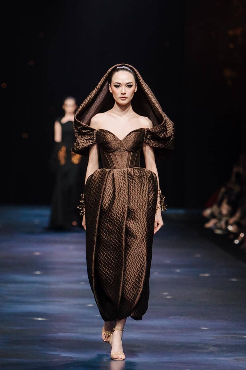 by @fawzypadly-3037.jpg, 1. Terdiri dari 77 set desain yang diciptakan lebih dari sekadar pakaian high-fashion, setiap rancangan adalah ode bagi keunikan setiap pribadi., 2. Koleksi 2025 “THE SIGN” merayakan keunikan tiap individu yang lahir dengan tanda pribadi yang tak akan pernah sama dengan orang lain., 3. Rentang warna menggunakan hitam, putih, biru tua, emas, perak, dan coral hadir dalam bahan lembut hingga tekstur jacquard, sifon, crepe, dan tulle, 4. Siluet kokoh arsitektural, solid, dengan pola eksperimental, ditata dengan permainan layer, dimensi dari transparansi, dan 3D dari aksen draping., 5. Aksen utama hadir lewat rasi bintang, galaksi misterius, dan sidik jari beads yang dirajut dengan detail ekstrem penuh savoir-faire.