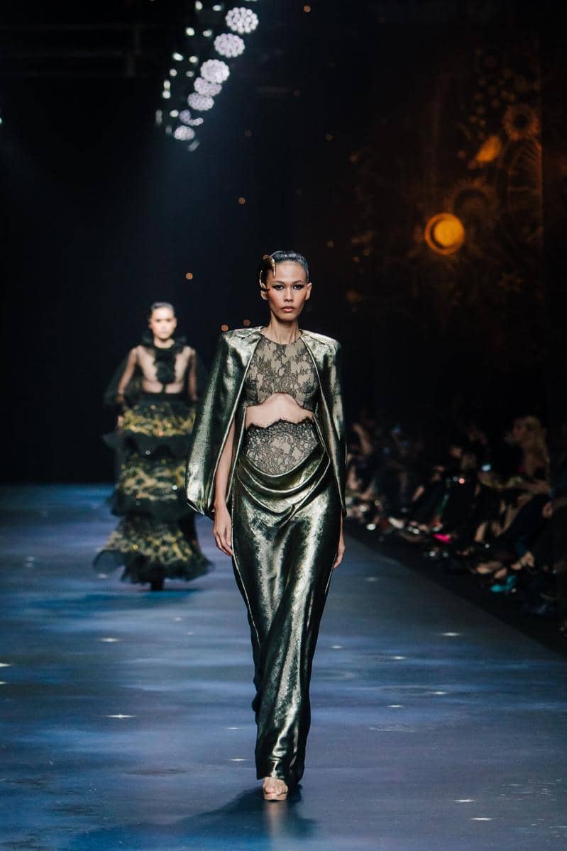 by @fawzypadly-2867.jpg, 1. Terdiri dari 77 set desain yang diciptakan lebih dari sekadar pakaian high-fashion, setiap rancangan adalah ode bagi keunikan setiap pribadi., 2. Koleksi 2025 “THE SIGN” merayakan keunikan tiap individu yang lahir dengan tanda pribadi yang tak akan pernah sama dengan orang lain., 3. Rentang warna menggunakan hitam, putih, biru tua, emas, perak, dan coral hadir dalam bahan lembut hingga tekstur jacquard, sifon, crepe, dan tulle, 4. Siluet kokoh arsitektural, solid, dengan pola eksperimental, ditata dengan permainan layer, dimensi dari transparansi, dan 3D dari aksen draping., 5. Aksen utama hadir lewat rasi bintang, galaksi misterius, dan sidik jari beads yang dirajut dengan detail ekstrem penuh savoir-faire.
