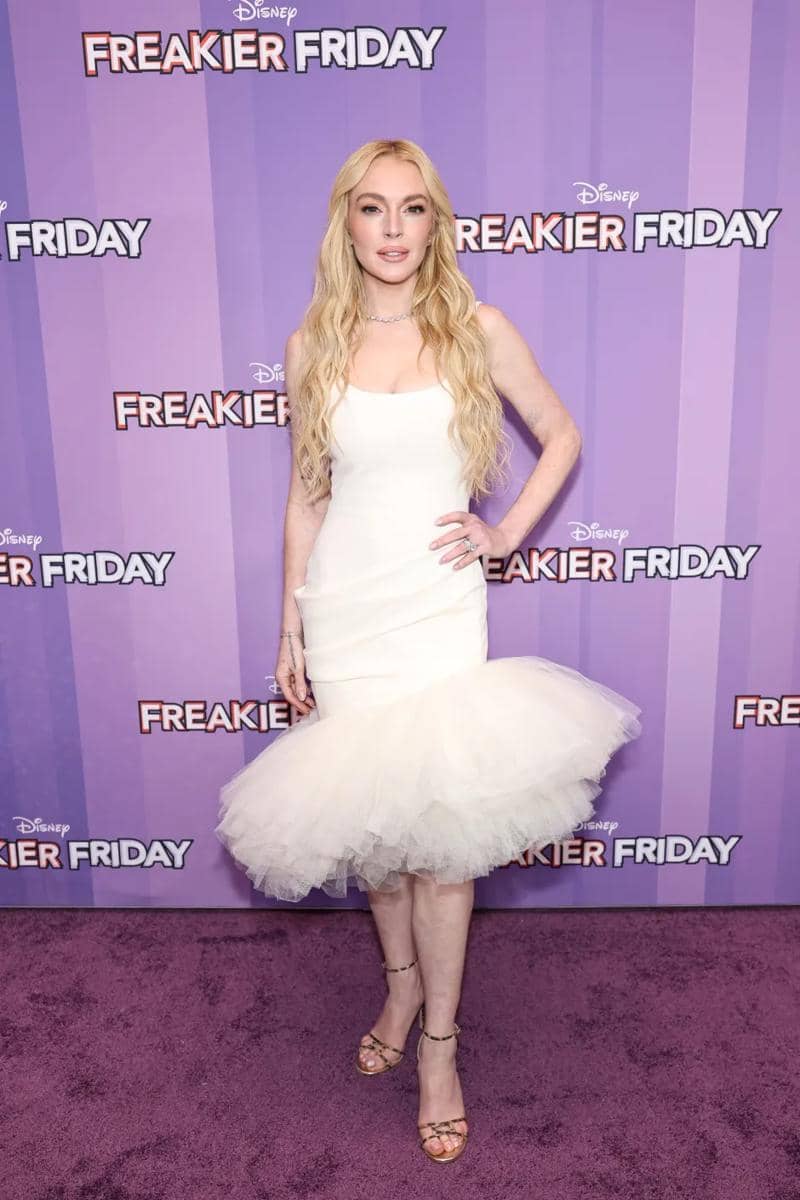 lindsay-lohan-attends-freakier-friday-1013011791.jpg, 1. Pakai tweed dress, LiLo bergaya seperti karakternya di sekuel film tahun 2003. Headband kuning dan kacamata bulat bawa nuansa retro di gayanya., 2. Di penampilan lainnya, Lindsay pakai cheongsam mini dress dengan detail floral dipadukan bersama heels sandal dan micro bag., 3. Saat screening film di New York, ia pakai dress putih dengan aksen tulle mengembang di bagian bawah rok. Elegan tapi tetap statement!, 4. Untuk premiere di LA, Lindsay pakai gaun flowy pink dari Miu Miu dilengkapi kalung berhias kristal yang bikin gayanya seperti princess. , 5. Tampil menonjol pakai gaun Balmain tanpa tali warna pink fuchsia dengan aksen drapery di sisi tengahnya. Gaun ini juga dilengkapi detail ruffle.
