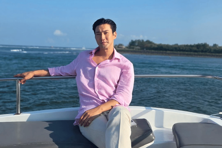 Untitled design (1).png, 1. Menikmati momen santai di pantai, Siwon pakai kemeja biru muda dipadukan celana pendek warna putih serta kacamata lensa biru., 2. Siwon berpose di kamar hotel mengenakan kaos polo warna merah dengan celana pendek serta Birkenstock Zürich sandal., 3. Siwon berpose topless dengan celana pendek saat menikmati pemandangan yang memukau di rooftop resort yang ditinggalinya., 4. Kali ini ia memadukan kemeja putih dan celana pendek saat menikmati pemandangan di rooftop. Siwon juga memakai signet ring di jari kelingkingnya., 5. Melihat pemandangan laut dengan menaiki boat, Siwon bergaya kasual padu padankan kemeja pink dan celana panjang warna putih.