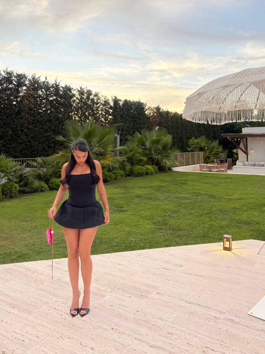 SnapInsta.to_527283355_18511812760066587_2572637219716557556_n.jpg, 1. Jadi salah satu tamu undangan Met Gala, Georgina mengenakan gaun satin hitam panjang dengan detail train rancangan Vetements., 2. Tunjukkan pesona balletcore sekaligus sporty, ia memadukan baju olahraga dari alo dengan stocking serta sepatu balet bernuansa pink., 3. Dengan gaya chic, Georgina tampil pede pakai strapless dress dengan rok super mini dipadukan bersama heels senada dan tas tangan pink., 4. Berpose di jalanan kota New York, gayanya tampak edgy memakai leather blazer dan stocking hitam serta kacamata yang bikin penampilannya tambah kece, 5. Georgina menunjukan pesonanya yang memukau di karpet merah dengan dress hitam beraksen kerutan dan hoop earrings sebagai pilihan aksesori.