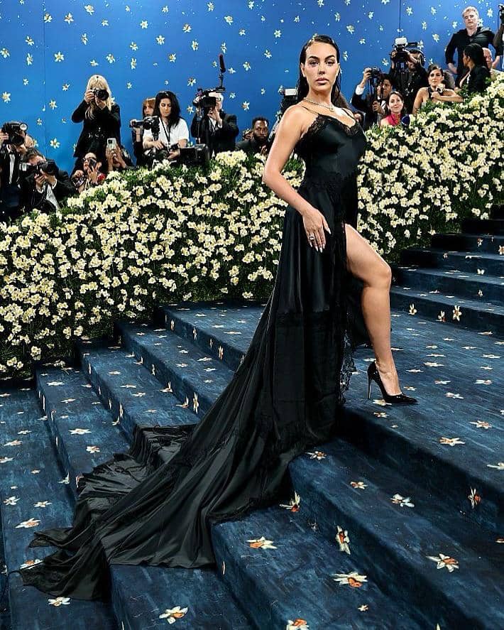 SnapInsta.to_495826954_18495891952066587_3882126272977452734_n.jpg, 1. Jadi salah satu tamu undangan Met Gala, Georgina mengenakan gaun satin hitam panjang dengan detail train rancangan Vetements., 2. Tunjukkan pesona balletcore sekaligus sporty, ia memadukan baju olahraga dari alo dengan stocking serta sepatu balet bernuansa pink., 3. Dengan gaya chic, Georgina tampil pede pakai strapless dress dengan rok super mini dipadukan bersama heels senada dan tas tangan pink., 4. Berpose di jalanan kota New York, gayanya tampak edgy memakai leather blazer dan stocking hitam serta kacamata yang bikin penampilannya tambah kece, 5. Georgina menunjukan pesonanya yang memukau di karpet merah dengan dress hitam beraksen kerutan dan hoop earrings sebagai pilihan aksesori.