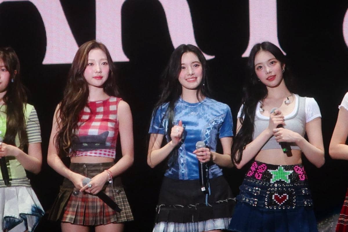 GzKf_2VaQAAWIAe.jpeg, 1. Member asal Indonesia, Carmen unjuk pesona di atas panggung pakai tank top putih, rok mini serta aksesori seperti belt dan bando merah., 2. Ye-On memilih kaos hijau dipadukan rok ruffle unik sementara Stella andalkan crop top motif kotak-kotak dan rok denim dengan detail lipit., 3. Yuha pakai babytee biru dengan rok mini hitam aksen pleats, sementara Ian tampil dengan layering crop top dan rok denim detail grafis., 4. Jiwoo tampil energik di atas panggung pakai tanktop gambar kucing dipadukan rok mini hitam yang punya aksen belt besar., 5. Juun pakai outfit warna coklat dengan tanktop dan rok yang senada. Sementara A-na memilih graphic tee dan rok pleats motif kotak-kotak. 