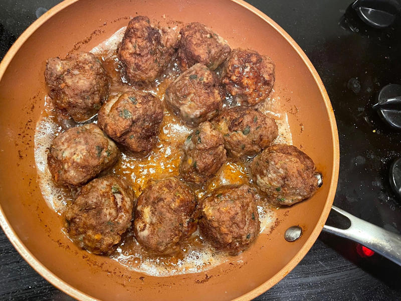 Before making the meatballs, we just need to do some quick prep., Then, mix everything together with your hands., Once your mixture is ready, start shaping the meatballs., Add the meatballs, one by one, into the pan., Use two forks to gently rotate each meatball every two minutes., It will take about 10 minutes to cook the meatballs.