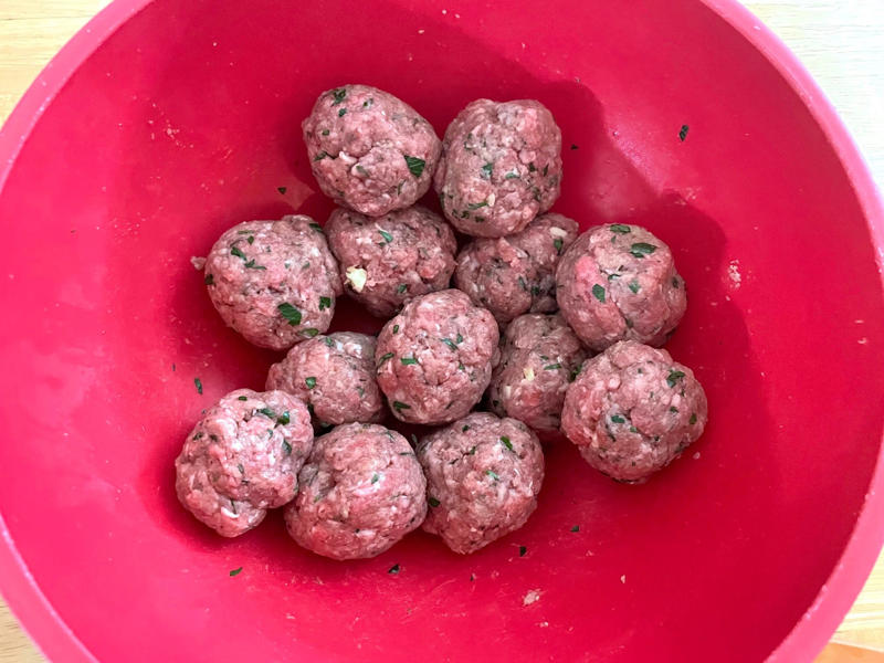Before making the meatballs, we just need to do some quick prep., Then, mix everything together with your hands., Once your mixture is ready, start shaping the meatballs., Add the meatballs, one by one, into the pan., Use two forks to gently rotate each meatball every two minutes., It will take about 10 minutes to cook the meatballs.