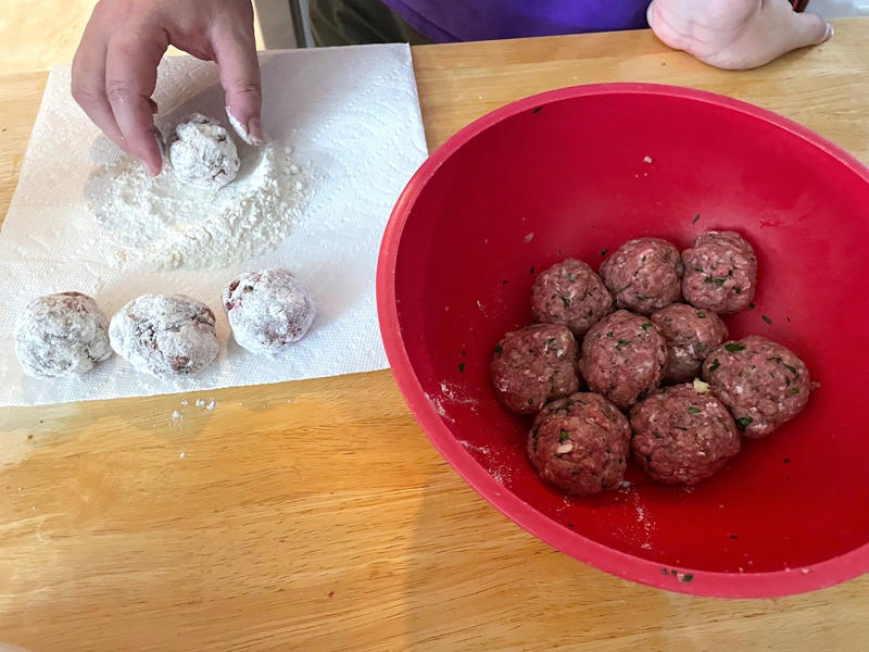 Before making the meatballs, we just need to do some quick prep., Then, mix everything together with your hands., Once your mixture is ready, start shaping the meatballs., Add the meatballs, one by one, into the pan., Use two forks to gently rotate each meatball every two minutes., It will take about 10 minutes to cook the meatballs.