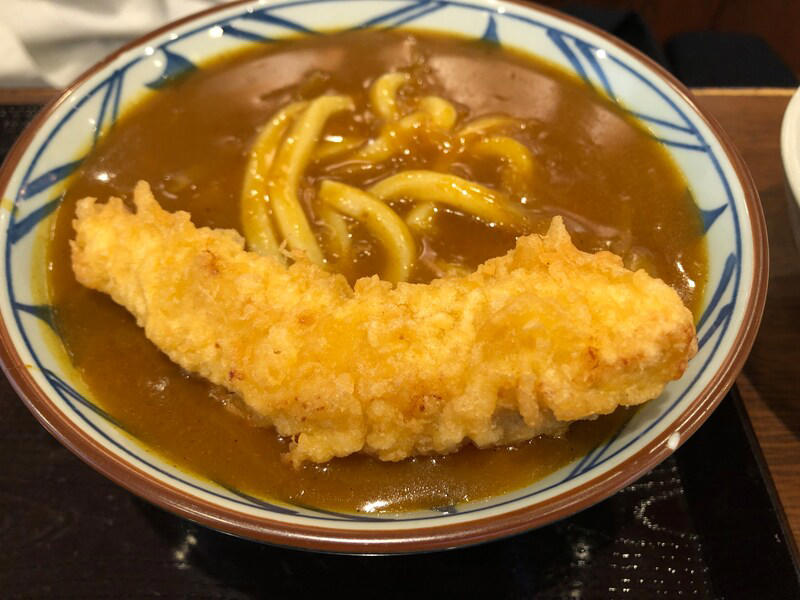 丸亀製麺の「カレーうどん」はたっぷりカレーが特徴, 丸亀製麺の「カレーうどん」は甘めのカレー。うどんに絡んでおいしい！ 口コミも紹介, 丸亀製麺の「カレーうどん」の値段・価格・コスパ, 丸亀製麺の「カレーうどん」の原材料・内容量・アレルギー情報, 丸亀製麺の「カレーうどん」のカロリー・栄養成分表示, 1.白ごはんでカレーライス, 2.人気No.1の天ぷら「かしわ天」を足す, 3.野菜かき揚げを足す, 4.半熟玉子天でカレーをまろやかに, 丸亀製麺の「カレーうどん」はテイクアウト（持ち帰り）できる？, 丸亀製麺の「トマたまカレーうどん」や「熱盛カレーうどん弁当」はいつまで？ 販売終了した？