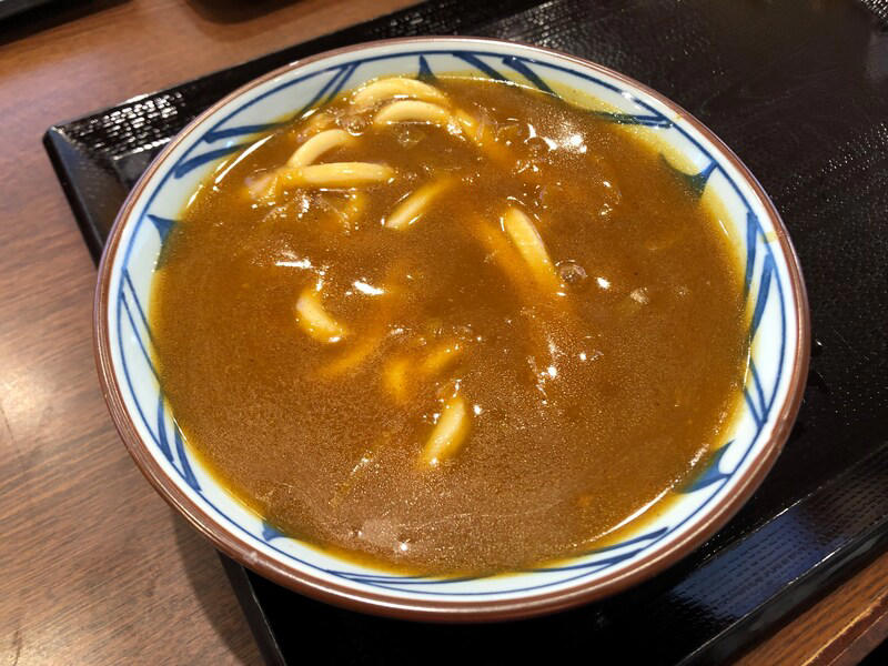 丸亀製麺の「カレーうどん」はたっぷりカレーが特徴, 丸亀製麺の「カレーうどん」は甘めのカレー。うどんに絡んでおいしい！ 口コミも紹介, 丸亀製麺の「カレーうどん」の値段・価格・コスパ, 丸亀製麺の「カレーうどん」の原材料・内容量・アレルギー情報, 丸亀製麺の「カレーうどん」のカロリー・栄養成分表示, 1.白ごはんでカレーライス, 2.人気No.1の天ぷら「かしわ天」を足す, 3.野菜かき揚げを足す, 4.半熟玉子天でカレーをまろやかに, 丸亀製麺の「カレーうどん」はテイクアウト（持ち帰り）できる？, 丸亀製麺の「トマたまカレーうどん」や「熱盛カレーうどん弁当」はいつまで？ 販売終了した？