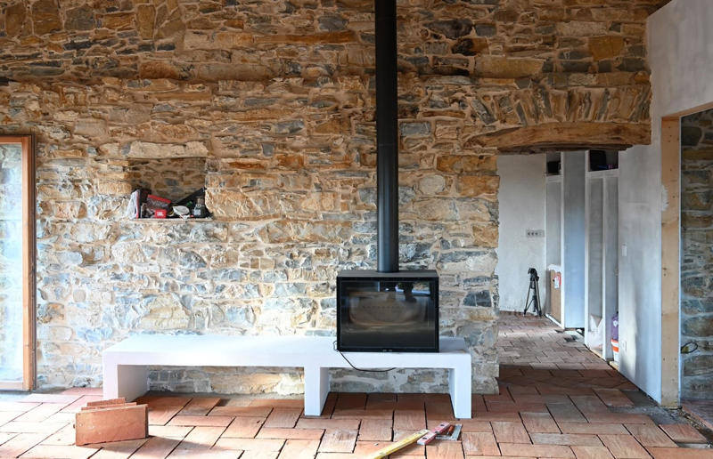 Creating a cosy living room Meet the architects who transformed a 100-year-old ruin into a sustainable home, A meeting of minds, Shopping for a home, Rescuing a ruin, Crumbling but charming, Getting started, Seven garden terraces, Moving inside, Dismantling the roof, Remains of a ruin, Structural issues, Rebuilding the roof, Salvaging materials, Sealing the roof, Old meets new, Eco materials, Starting on the floors, Creating rooms, Insulation, insulation, insulation, Custom windows, Getting airtight, Plastering problems, Dressing the stone, Let there be light!, Laying the floors, Creating a cosy living room, A welcoming living space, Perfect for entertaining, DIY kitchen, An eco-conscious cooking spot, Polished bathroom walls, Ready for a spa session, A reclaimed patio, Breathtaking backyard views, Olives and lavender
