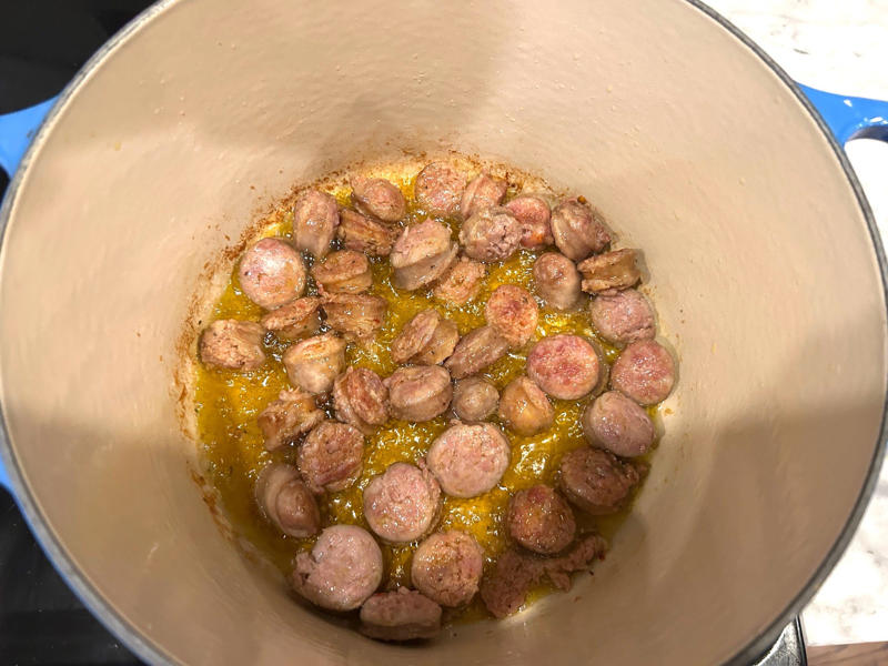 I took my sausages out of the oven, sliced each link into ½-inch pieces, and threw them into the pot. Ina Garten's orecchiette pasta features two types of sausage and broccoli rabe., First, I preheated the oven to 350 degrees Fahrenheit and prepped the sausages., After cooking the sausages for five minutes, I added the garlic., Then, it was time to add the tomatoes and wine.