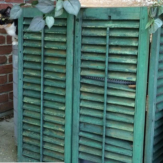 Hide AC Unit with a Living Garden AC Cover, Hide AC Unit with a Modern Outdoor AC Cover, AC Cover/Tool Shed, Hide AC Unit with Tall Shrubs, Hide AC Unit with Birdhouse Picket Fence, Hide AC Unit with a Shabby Chic Shutter Screen, Hide AC Unit with an Iron Trellis, Hide AC Unit with a Multi-Purpose Structure, Hide AC Unit with an Outdoor Privacy Screen