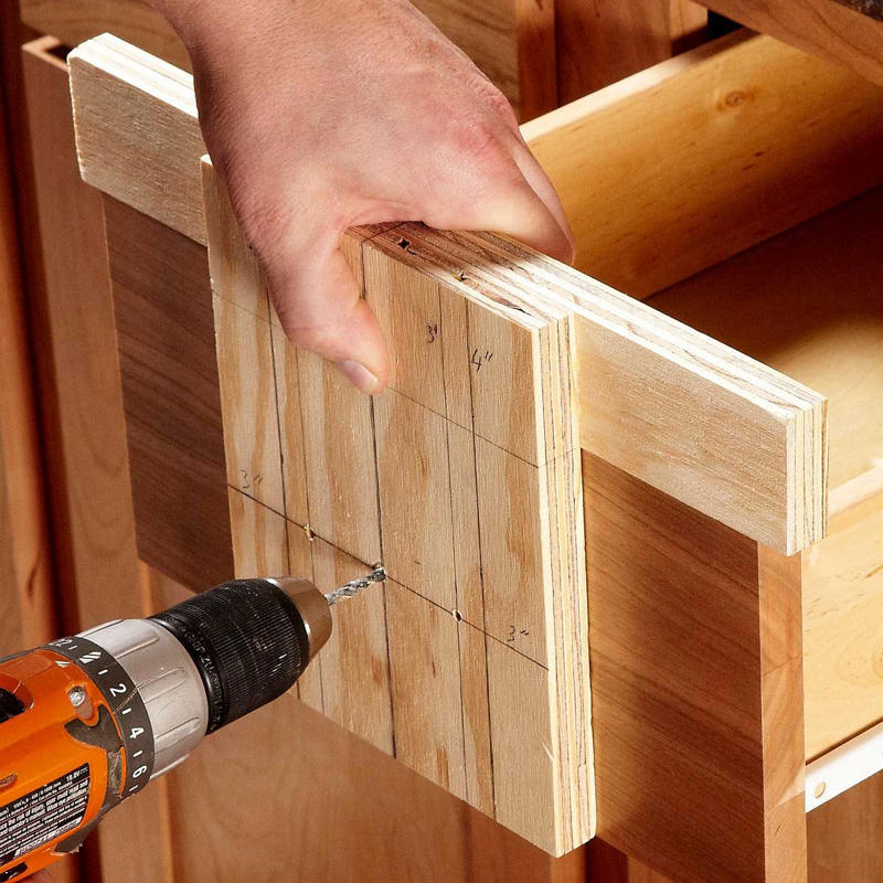 Make a Simple Drawer Template 13 Tips To Install Cabinet Hardware Perfectly Every Time Gettyimages 1389698183 Ft, Use the Door Rail as a Guide, Hide Old Holes With Back Plates, Make a Simple Drawer Template, Two-Sided Templates Prevent Tear-Out, Use Thread Sealant to Keep the Screws Tight, Mix Putty to Match, Install Hardware Higher on the Lowest Drawer, Perfect Finish Touch-Ups