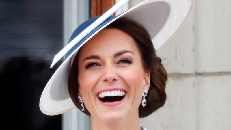 Kate Middleton wearing a white blazer and a navy blue hat, watches a flypast from the balcony of Buckingham Palace during Trooping the Colour on June 2, 2022 in London, England.