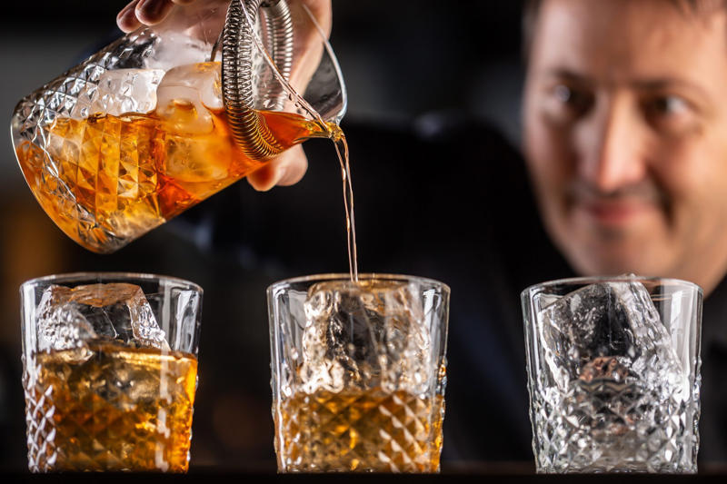 Asking them to do a shot with you, Picking up your drink before they give it to you, Cleaning up broken glass, Stuffing napkins, straw wrappers or other trash into your cup, Reaching over or behind the bar to grab something quickly, Buying a round of drinks, Young Hispter Bartender Talking With Customers, Requesting a custom cocktail or ordering off-menu, Using beverage napkins to clean up a spill, Not bothering them with safety concerns