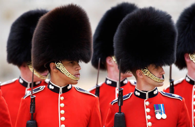 Their hats are old, big, and heavy They’re part of British history, They need to be tall, They need to pass an exam, They go through a demanding training program, Remuneration package, They are early birds, They have to be resilient, Their hats are old, big, and heavy, They wear their hats in a peculiar way, Their uniforms must be in top-notch condition at all times, They may faint, Hot weather can be a nightmare, They can still serve their country in military operations, They might chat with members of the royal family