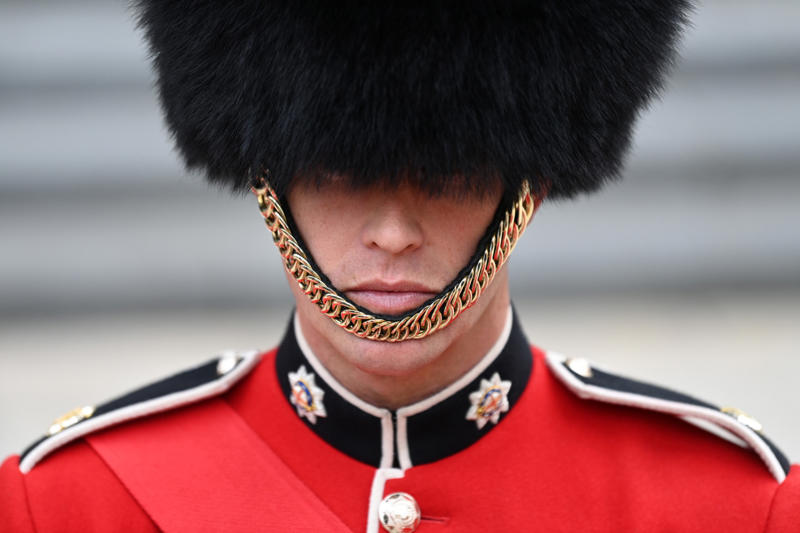 They wear their hats in a peculiar way They’re part of British history, They need to be tall, They need to pass an exam, They go through a demanding training program, Remuneration package, They are early birds, They have to be resilient, Their hats are old, big, and heavy, They wear their hats in a peculiar way, Their uniforms must be in top-notch condition at all times, They may faint, Hot weather can be a nightmare, They can still serve their country in military operations, They might chat with members of the royal family