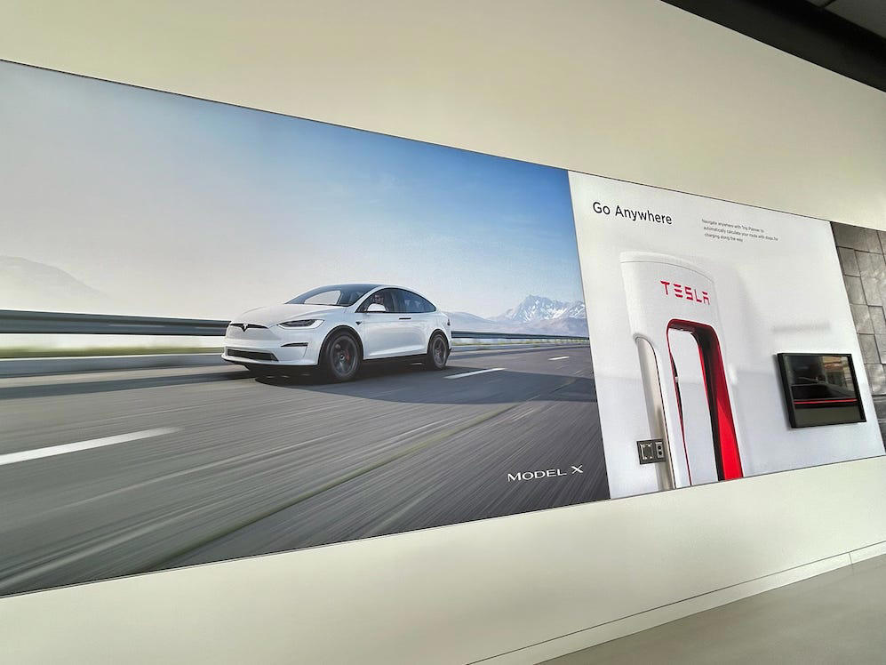 The wall posters were more show than tell. It had two EVs featured in the store., Rivian had Boxed Water in a basket at the door., The decor was colorful, outdoorsy, and relaxed., A Rivian spokesperson told me that the store is designed for families., The store had a merchandise section with locally sourced reusable bags, A Rivian employee took me on a test drive., I didn't see too many customers during my visit., I went to Tesla's showroom in the Meatpacking District the next day., The store's design was tech-forward, sleek, and futuristic., Tesla had some interactive elements in the space., The wall posters were more show than tell., The space also showed off Tesla's tech., Tesla's Optimus humanoid robot was on display., The staff seemed used to tourists popping in and taking photos., I was offered an espresso while I waited for my test ride., To sum it up: I enjoyed both experiences.