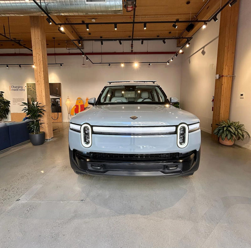 It had two EVs featured in the store. It had two EVs featured in the store., Rivian had Boxed Water in a basket at the door., The decor was colorful, outdoorsy, and relaxed., A Rivian spokesperson told me that the store is designed for families., The store had a merchandise section with locally sourced reusable bags, A Rivian employee took me on a test drive., I didn't see too many customers during my visit., I went to Tesla's showroom in the Meatpacking District the next day., The store's design was tech-forward, sleek, and futuristic., Tesla had some interactive elements in the space., The wall posters were more show than tell., The space also showed off Tesla's tech., Tesla's Optimus humanoid robot was on display., The staff seemed used to tourists popping in and taking photos., I was offered an espresso while I waited for my test ride., To sum it up: I enjoyed both experiences.