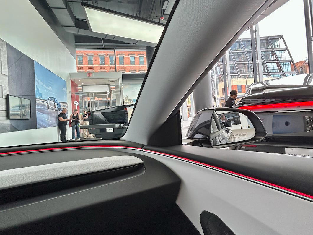 There was a steady flow of visitors from the moment I arrived until I left. It had two EVs featured in the store., Rivian had Boxed Water in a basket at the door., The decor was colorful, outdoorsy, and relaxed., A Rivian spokesperson told me that the store is designed for families., The store had a merchandise section with locally sourced reusable bags, A Rivian employee took me on a test drive., I didn't see too many customers during my visit., I went to Tesla's showroom in the Meatpacking District the next day., The store's design was tech-forward, sleek, and futuristic., Tesla had some interactive elements in the space., The wall posters were more show than tell., The space also showed off Tesla's tech., Tesla's Optimus humanoid robot was on display., The staff seemed used to tourists popping in and taking photos., I was offered an espresso while I waited for my test ride., To sum it up: I enjoyed both experiences.