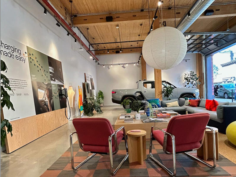 It kind of felt like the EV version of a Patagonia store — the vibes were upscale and granola. It had two EVs featured in the store., Rivian had Boxed Water in a basket at the door., The decor was colorful, outdoorsy, and relaxed., A Rivian spokesperson told me that the store is designed for families., The store had a merchandise section with locally sourced reusable bags, A Rivian employee took me on a test drive., I didn't see too many customers during my visit., I went to Tesla's showroom in the Meatpacking District the next day., The store's design was tech-forward, sleek, and futuristic., Tesla had some interactive elements in the space., The wall posters were more show than tell., The space also showed off Tesla's tech., Tesla's Optimus humanoid robot was on display., The staff seemed used to tourists popping in and taking photos., I was offered an espresso while I waited for my test ride., To sum it up: I enjoyed both experiences.
