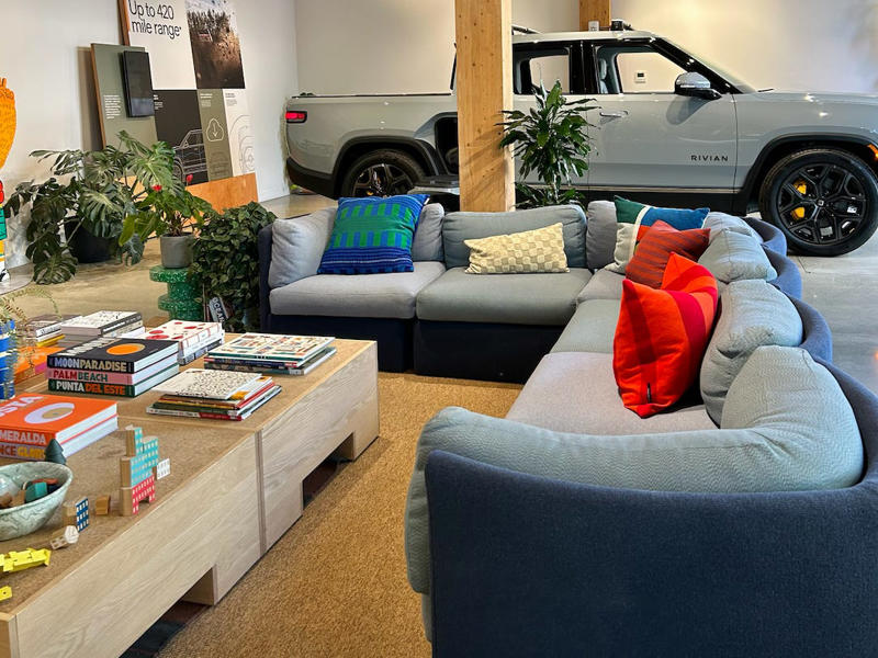 The massive L couch in the middle of the store was a highlight. It had two EVs featured in the store., Rivian had Boxed Water in a basket at the door., The decor was colorful, outdoorsy, and relaxed., A Rivian spokesperson told me that the store is designed for families., The store had a merchandise section with locally sourced reusable bags, A Rivian employee took me on a test drive., I didn't see too many customers during my visit., I went to Tesla's showroom in the Meatpacking District the next day., The store's design was tech-forward, sleek, and futuristic., Tesla had some interactive elements in the space., The wall posters were more show than tell., The space also showed off Tesla's tech., Tesla's Optimus humanoid robot was on display., The staff seemed used to tourists popping in and taking photos., I was offered an espresso while I waited for my test ride., To sum it up: I enjoyed both experiences.