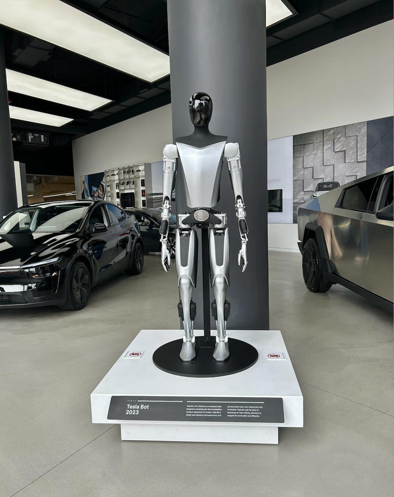 Tesla's Optimus humanoid robot was on display. It had two EVs featured in the store., Rivian had Boxed Water in a basket at the door., The decor was colorful, outdoorsy, and relaxed., A Rivian spokesperson told me that the store is designed for families., The store had a merchandise section with locally sourced reusable bags, A Rivian employee took me on a test drive., I didn't see too many customers during my visit., I went to Tesla's showroom in the Meatpacking District the next day., The store's design was tech-forward, sleek, and futuristic., Tesla had some interactive elements in the space., The wall posters were more show than tell., The space also showed off Tesla's tech., Tesla's Optimus humanoid robot was on display., The staff seemed used to tourists popping in and taking photos., I was offered an espresso while I waited for my test ride., To sum it up: I enjoyed both experiences.