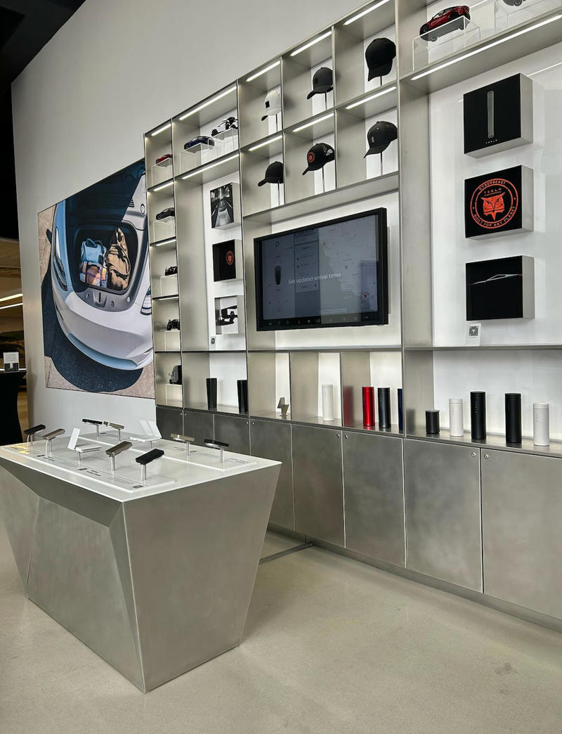Tesla also had a merch section, but it was centered on its most popular products and less wilderness-focused. It had two EVs featured in the store., Rivian had Boxed Water in a basket at the door., The decor was colorful, outdoorsy, and relaxed., A Rivian spokesperson told me that the store is designed for families., The store had a merchandise section with locally sourced reusable bags, A Rivian employee took me on a test drive., I didn't see too many customers during my visit., I went to Tesla's showroom in the Meatpacking District the next day., The store's design was tech-forward, sleek, and futuristic., Tesla had some interactive elements in the space., The wall posters were more show than tell., The space also showed off Tesla's tech., Tesla's Optimus humanoid robot was on display., The staff seemed used to tourists popping in and taking photos., I was offered an espresso while I waited for my test ride., To sum it up: I enjoyed both experiences.