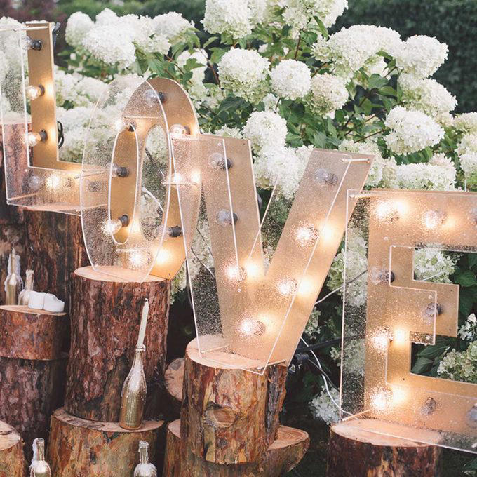 A Photo Journey of Your Story, Ample Outdoor Reception Lighting, Hang Chandeliers From Trees, Birdseed Confetti, DIY Photo Booth, Make Your Own Seating, Pallet Dance Floor, Succulent Wedding Gifts, DIY Wooden Wedding Arch, Tree Stump Centerpieces, Whimsical Light Bulbs Flower Holders, Lawn Games, Wooden Direction Signs, Use What You Have, DIY Wedding Decorations Concrete Numbers or Letters, Accommodate for the Weather, Arbor Seating, Use Your Resources Wisely, Marquee Letters