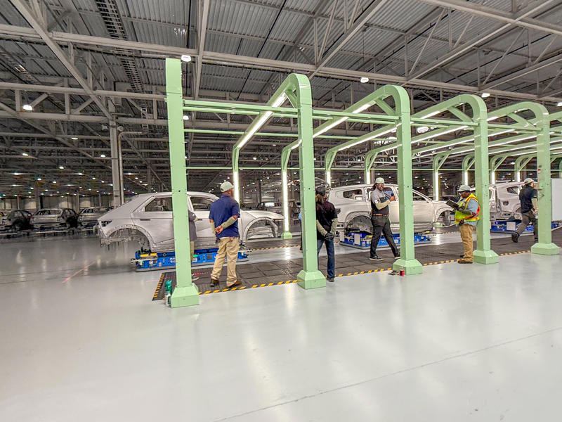The work done by the welding robots is then inspected by the plant's human employees known as Meta Pros. My tour began in the plant's modern main lobby., The Metaplant site consists of 11 buildings totalling 7.5 million square feet of space., Stamped parts are transported by automated guided vehicles, or AGVs., The stamped metal panels are then stored in these massive racks., Here are parts of the Ioniq 9, Hyundai's new flagship three-row EV SUV., The next part of the tour is the welding shop., The vehicles' interiors are then assembled by hand.