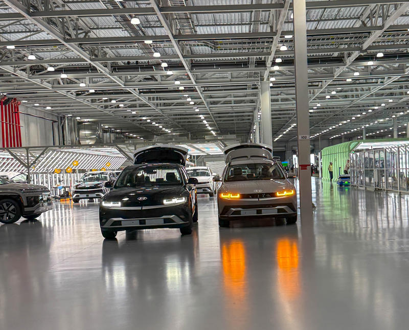 At the end of the assembly line, completed EVs are put through their paces at the on-site test track before being sent to the vehicle preparation center, or VPC, to get them ready for shipping. My tour began in the plant's modern main lobby., The Metaplant site consists of 11 buildings totalling 7.5 million square feet of space., Stamped parts are transported by automated guided vehicles, or AGVs., The stamped metal panels are then stored in these massive racks., Here are parts of the Ioniq 9, Hyundai's new flagship three-row EV SUV., The next part of the tour is the welding shop., The vehicles' interiors are then assembled by hand.