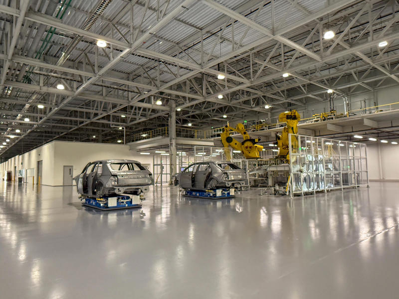 After the inspections are complete, a robot loads the partially assembled vehicles onto a conveyor system. My tour began in the plant's modern main lobby., The Metaplant site consists of 11 buildings totalling 7.5 million square feet of space., Stamped parts are transported by automated guided vehicles, or AGVs., The stamped metal panels are then stored in these massive racks., Here are parts of the Ioniq 9, Hyundai's new flagship three-row EV SUV., The next part of the tour is the welding shop., The vehicles' interiors are then assembled by hand.