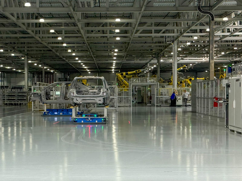 The next part of the tour is the welding shop. My tour began in the plant's modern main lobby., The Metaplant site consists of 11 buildings totalling 7.5 million square feet of space., Stamped parts are transported by automated guided vehicles, or AGVs., The stamped metal panels are then stored in these massive racks., Here are parts of the Ioniq 9, Hyundai's new flagship three-row EV SUV., The next part of the tour is the welding shop., The vehicles' interiors are then assembled by hand.